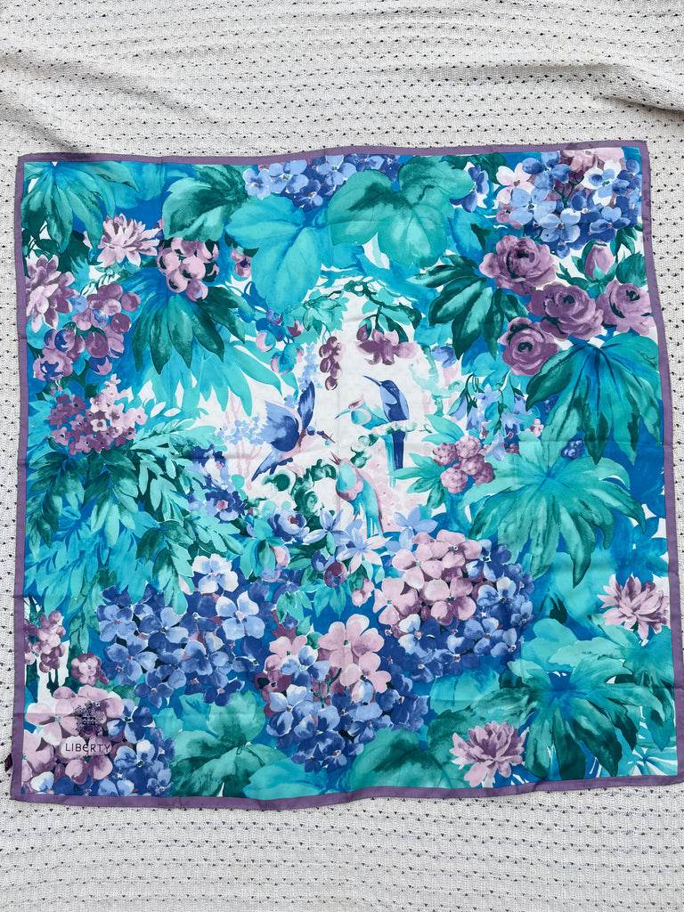 Vintage Liberty of London silk scarf with turquoise, teal, blue and purple floral bird print displayed fully open.