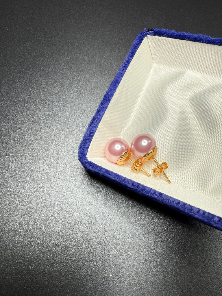 Pair of vintage pink faux pearl stud earrings displayed in blue jewellery box