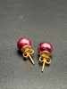 Back view of dark pink faux pearl stud earrings showing gold-tone posts and butterfly backs