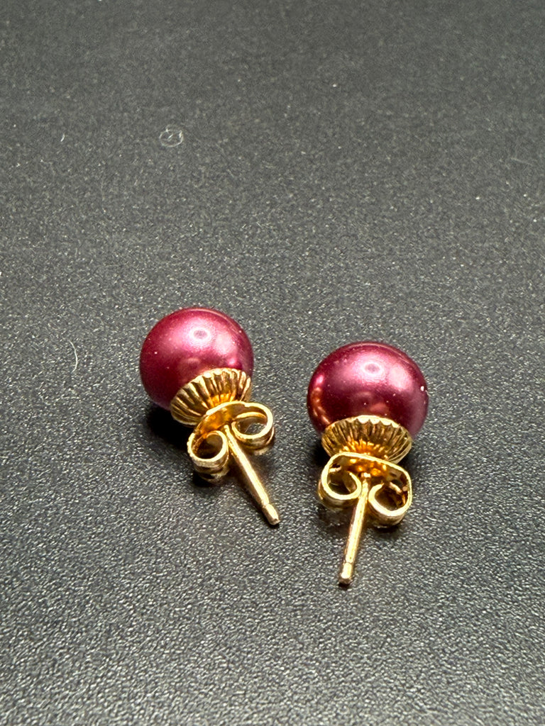Back view of dark pink faux pearl stud earrings showing gold-tone posts and butterfly backs