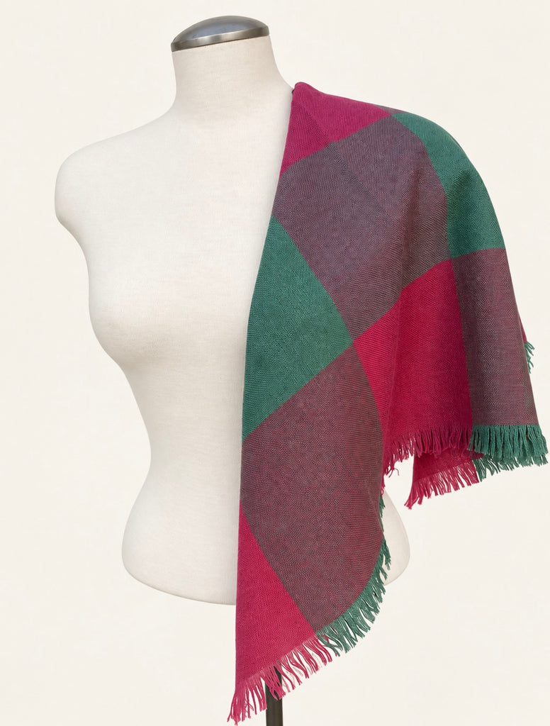 Vintage pink and teal wool scarf draped over white mannequin