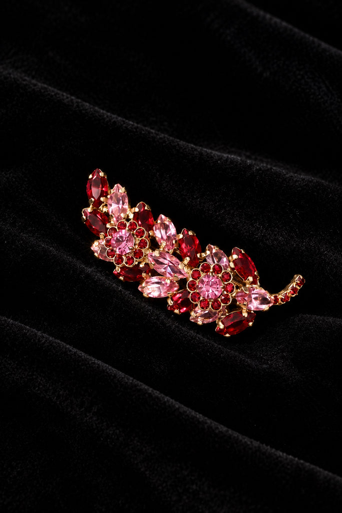 Close-up of unsigned Juliana-style gold-tone branch brooch with pink and red glass rhinestones