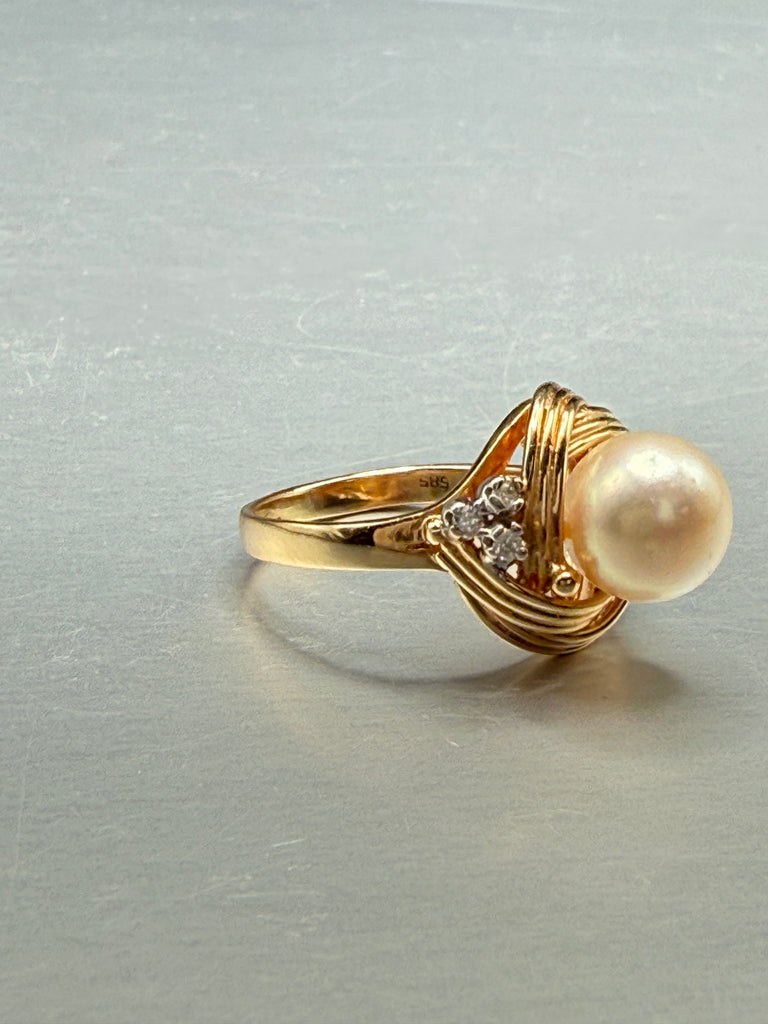 Close-up of cream pearl centre and diamond accents on vintage 14K yellow gold ring