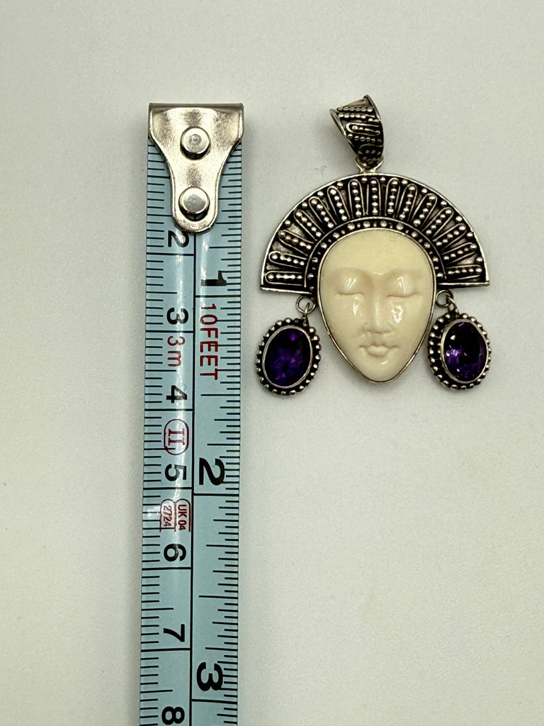 Vintage Balinese goddess silver pendant beside measuring tape showing approximately 1.75 inch length