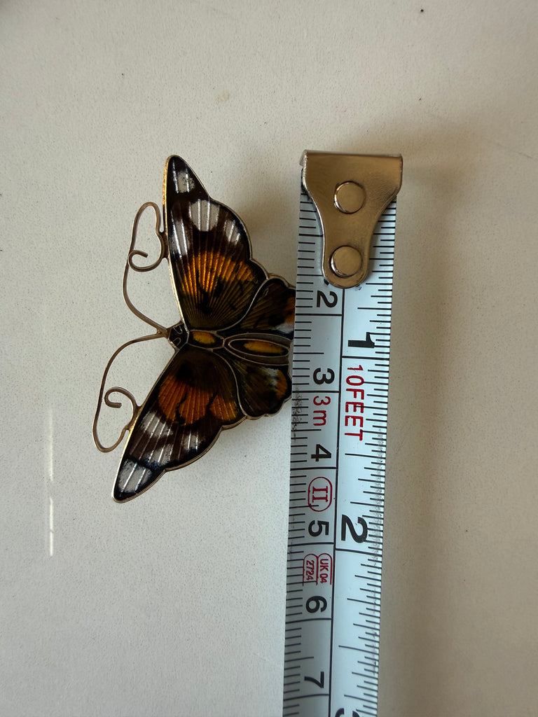 Vintage David-Andersen butterfly brooch beside measuring tape showing width