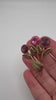Vintage Made in Austria crystal brooch shown in hand with three pink and purple stones