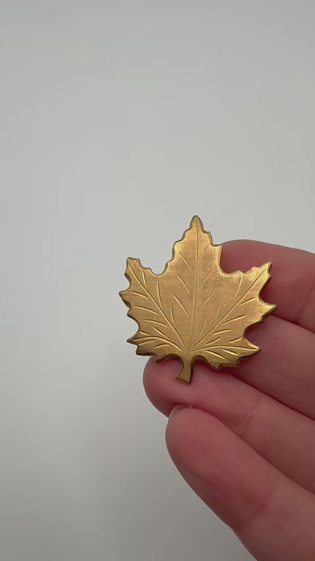Vintage Canadian maple leaf brooch shown in hand for scale