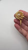 Large vintage gold tone floral brooch with faux pearl centre shown in hand for scale