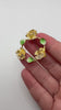 Yellow rose enamel wreath brooch shown in hand for scale